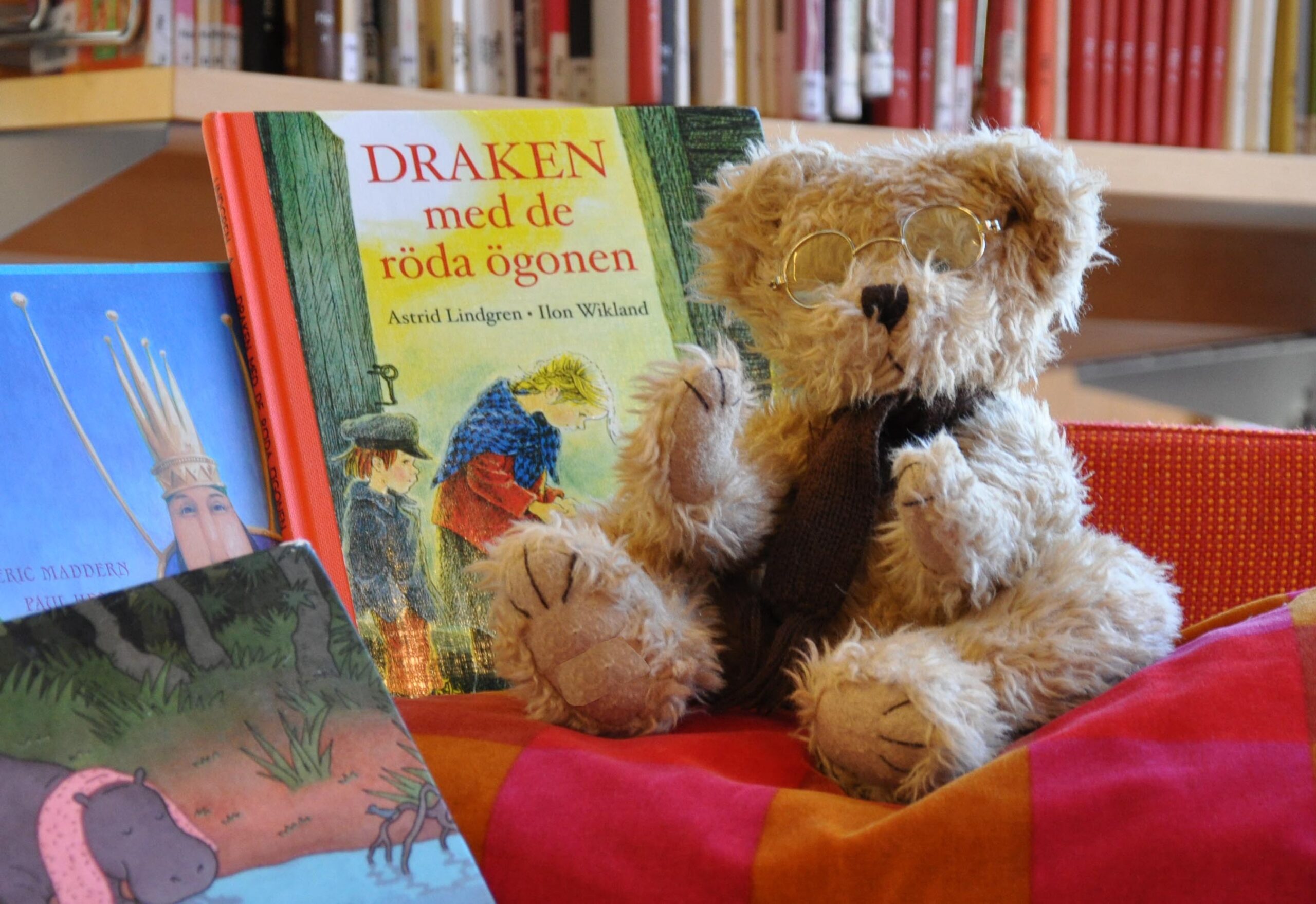 En nallebjörn sitter bredvid sagoböcker.