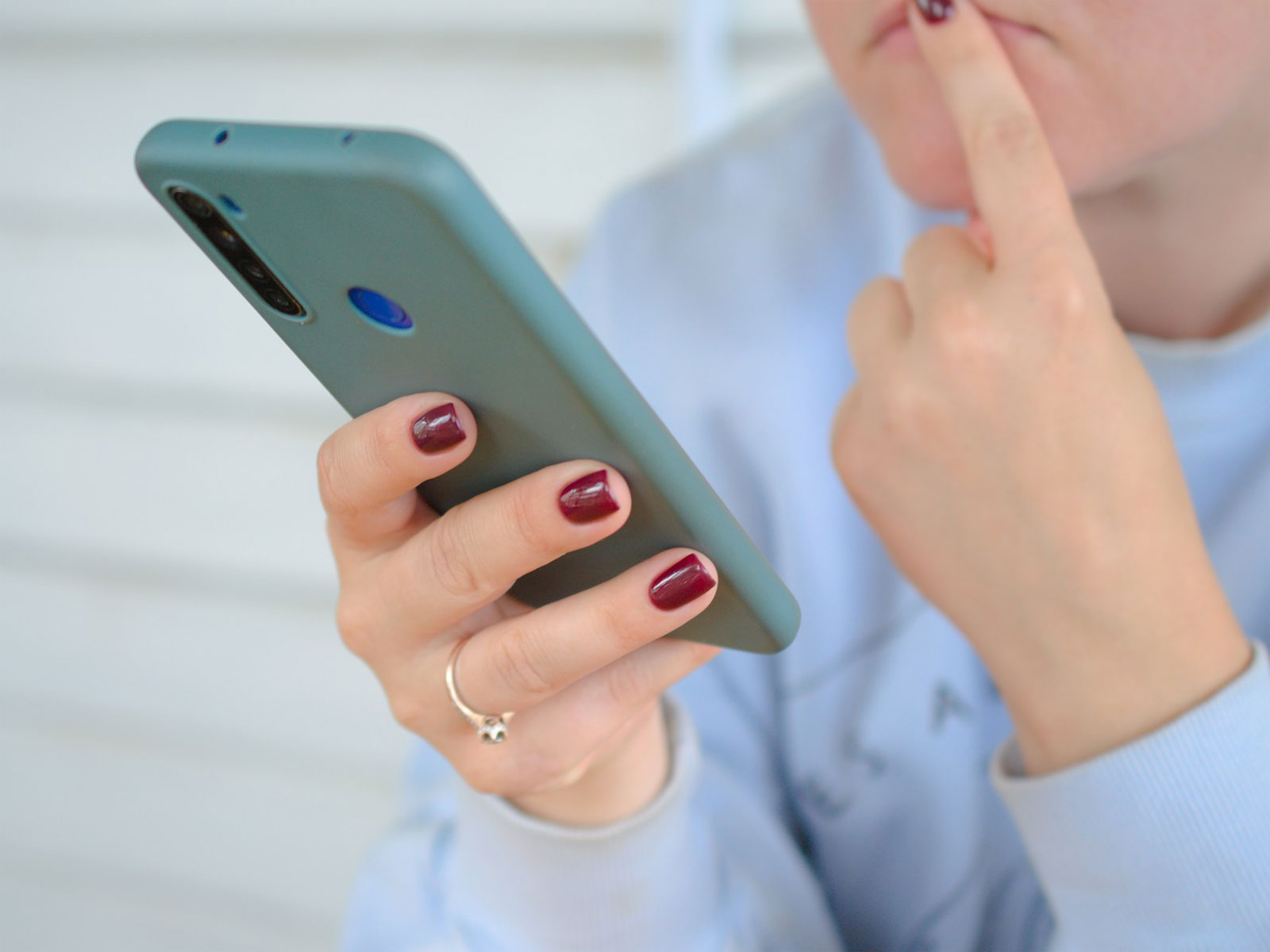 Tittar fundersamt på mobiltelefonen.