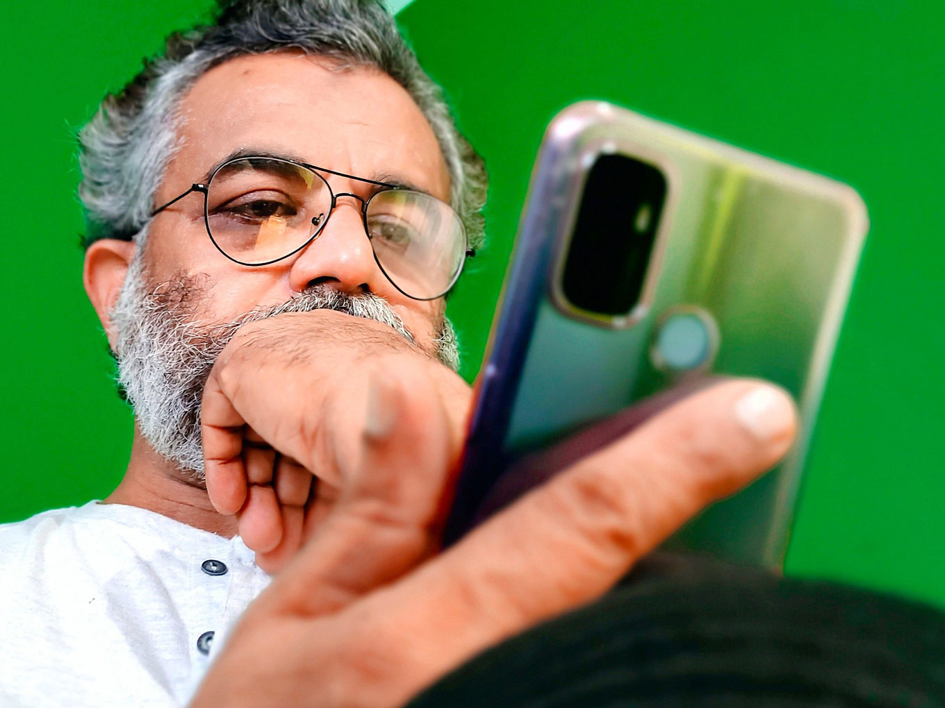 Person ser fundersamt på sin mobiltelefon.