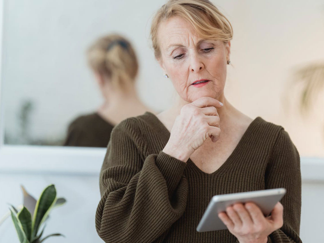 Person ser fundersamt på sin surfplatta.