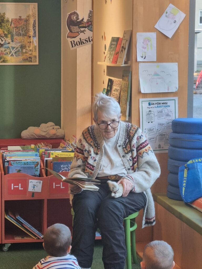 Måd som sitter och läser en saga för barn