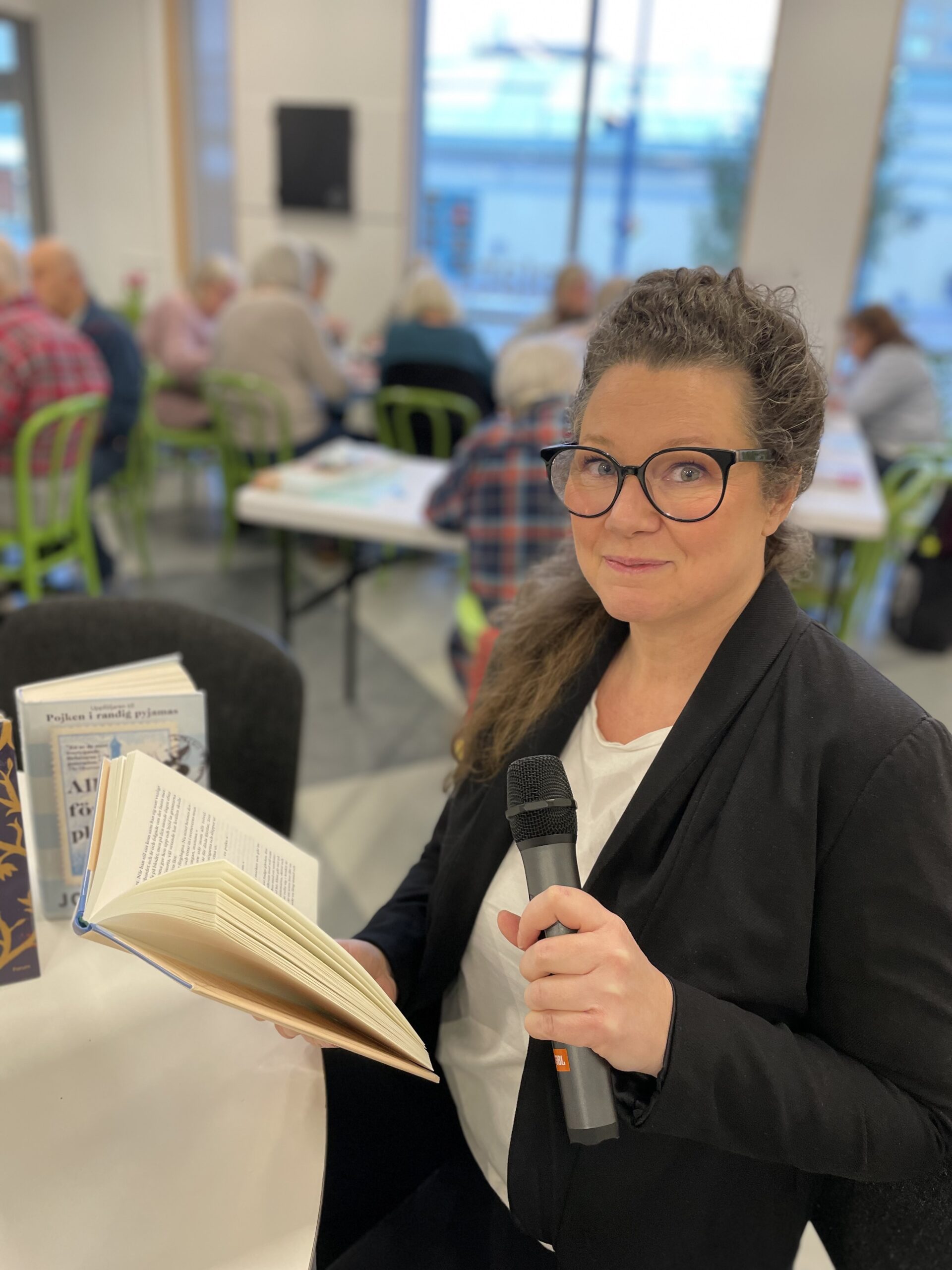 Kvinna som håller i en bok och i en mikrofon