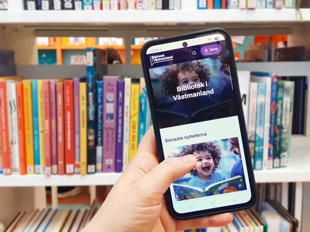 Mobiltelefon med bibliotekets nya webbplats på skärmen.