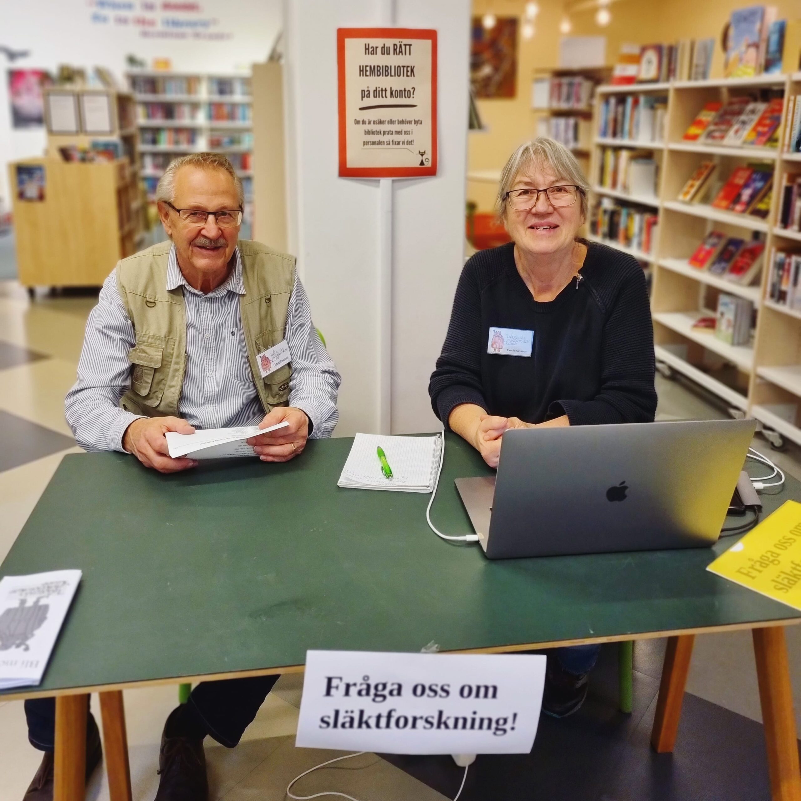 Bild på två personer i ett bibliotek