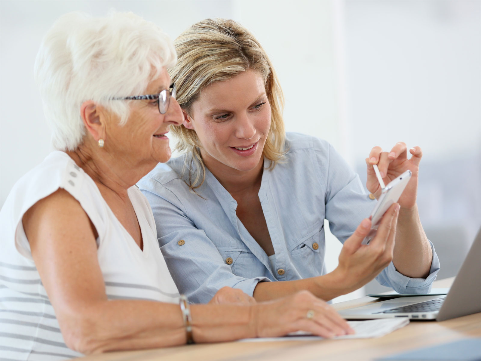 En person visar en annan något på mobiltelefonen.