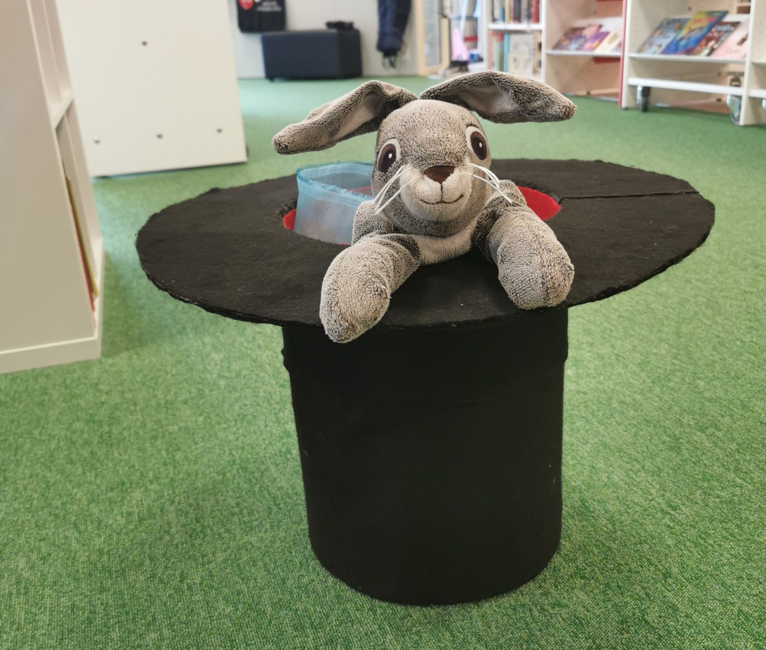 en gosedjurskanin som tittar upp ur en hatt