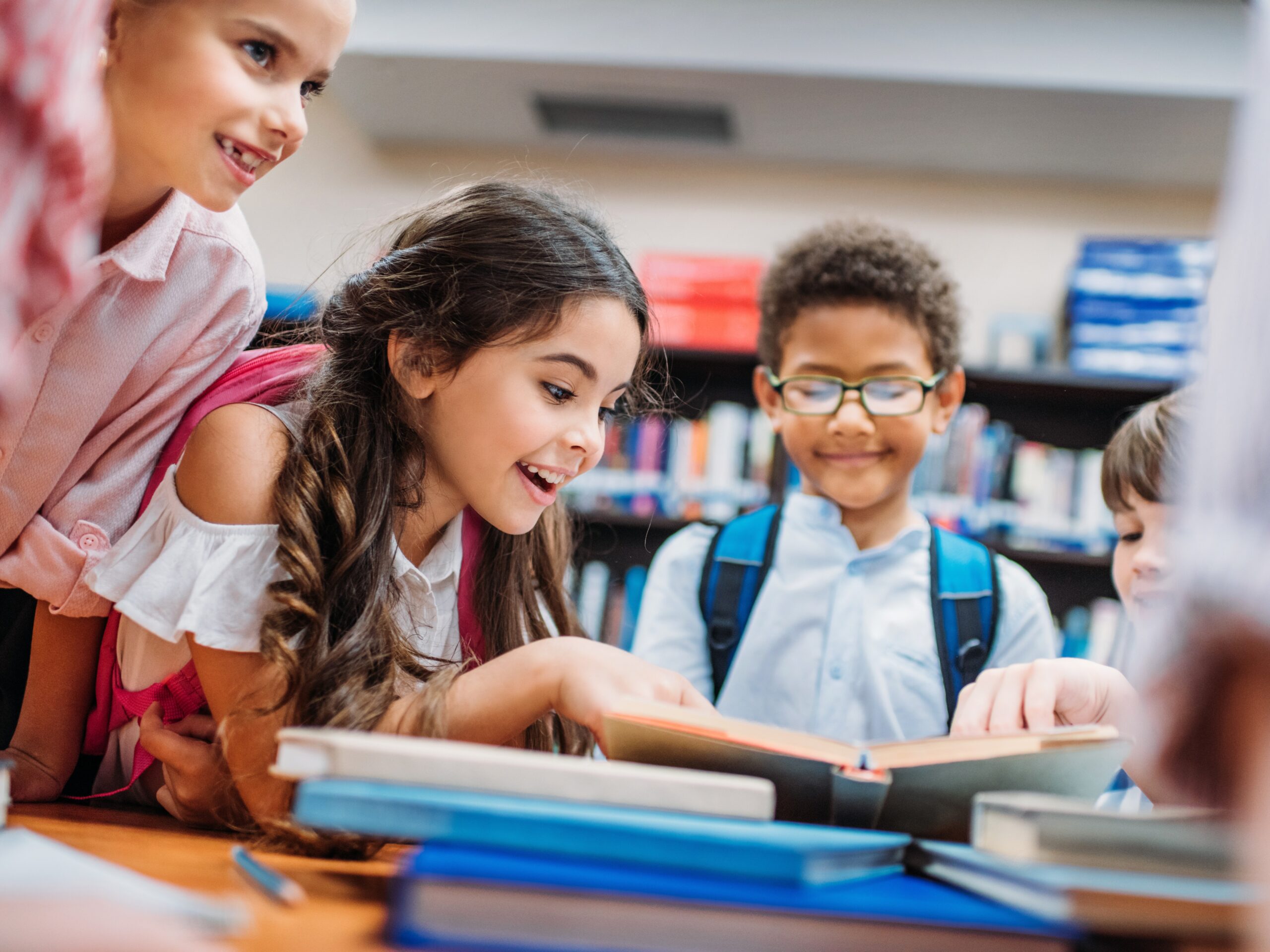 Barn på biblioteket tittar i en bok