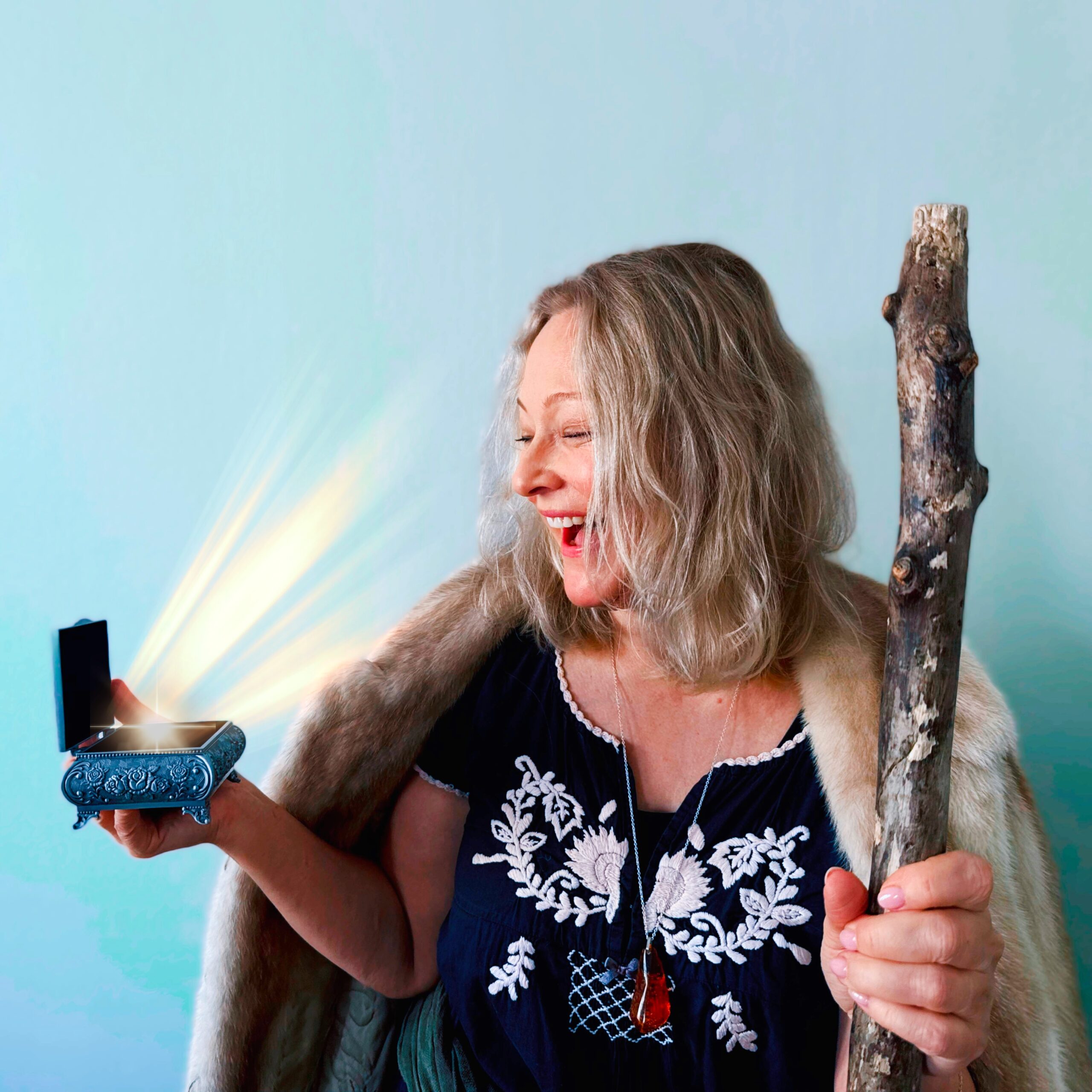 En kvinna håller en magisk ask och en trollstav i handen.