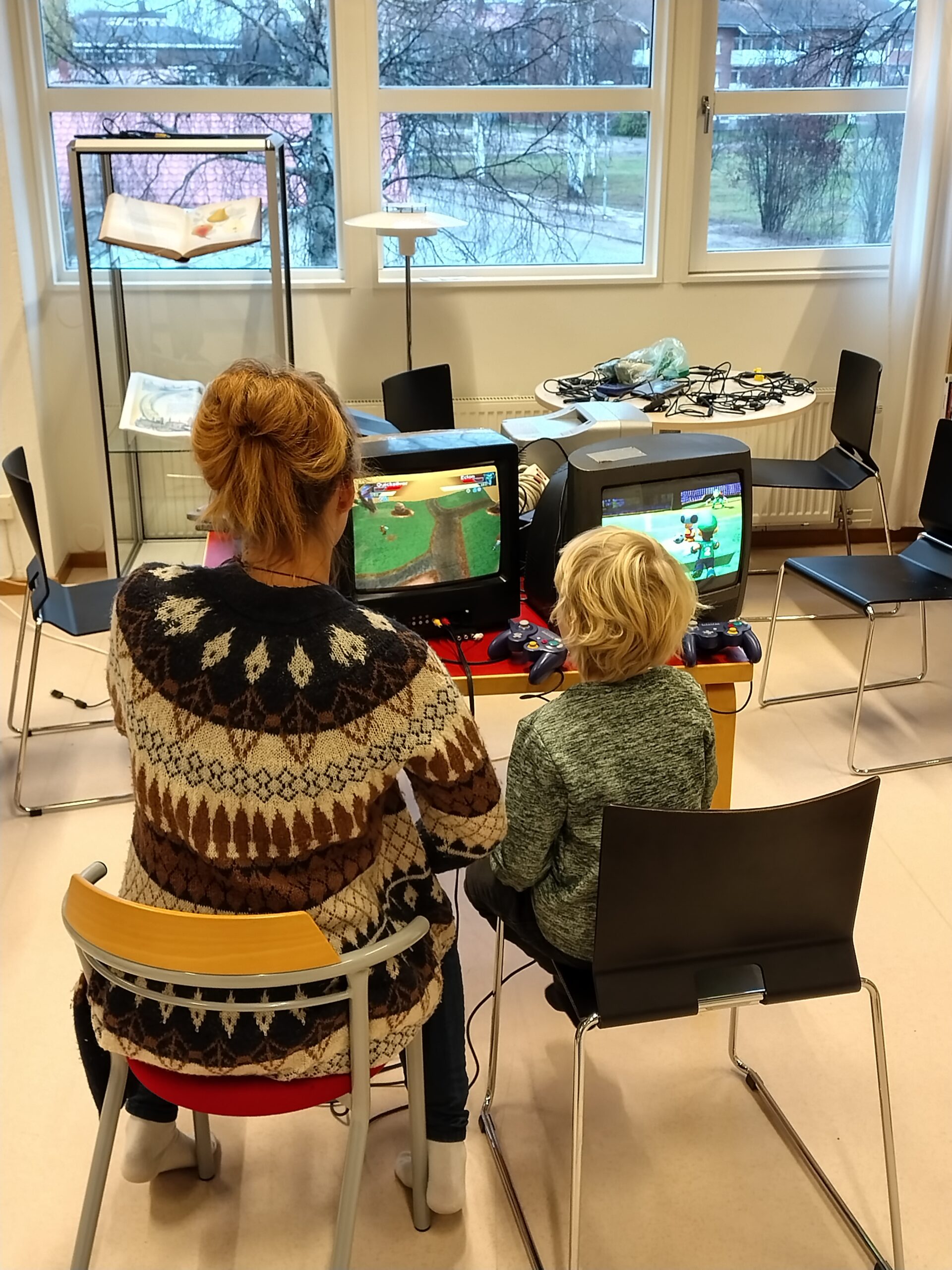Vuxen och barn spelar tv-spel tillsammans.