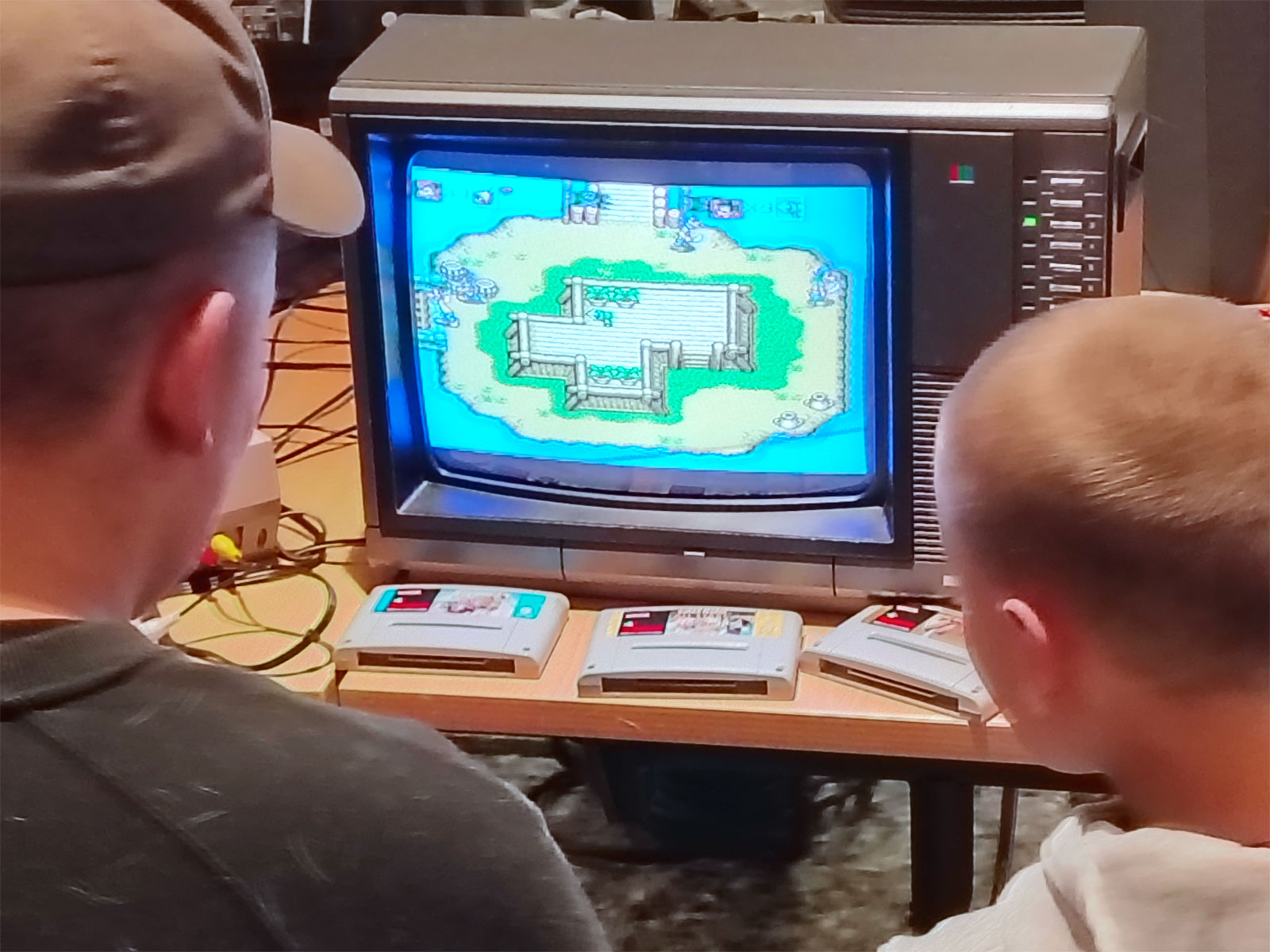 Vuxen och barn spelar gammalt tv-spel på en tjock-tv.