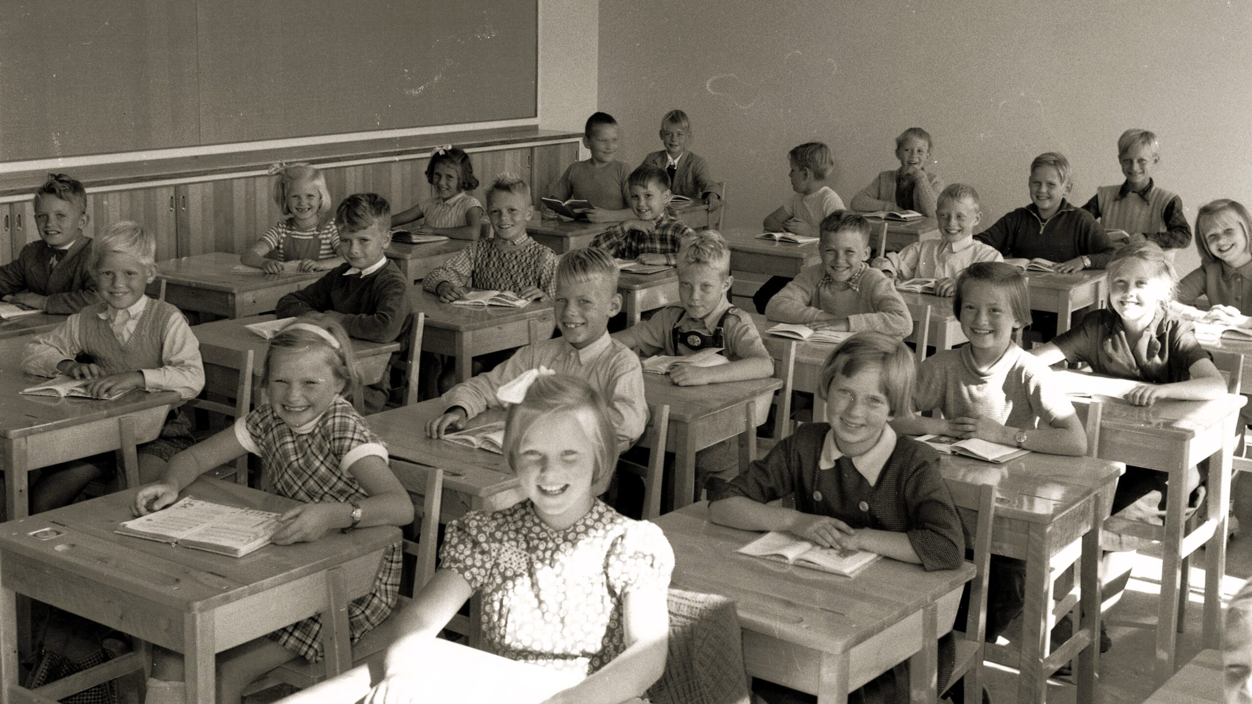 Foto från Gäddgårdsskolans invigning. Elever sitter i sina skolbänkar.