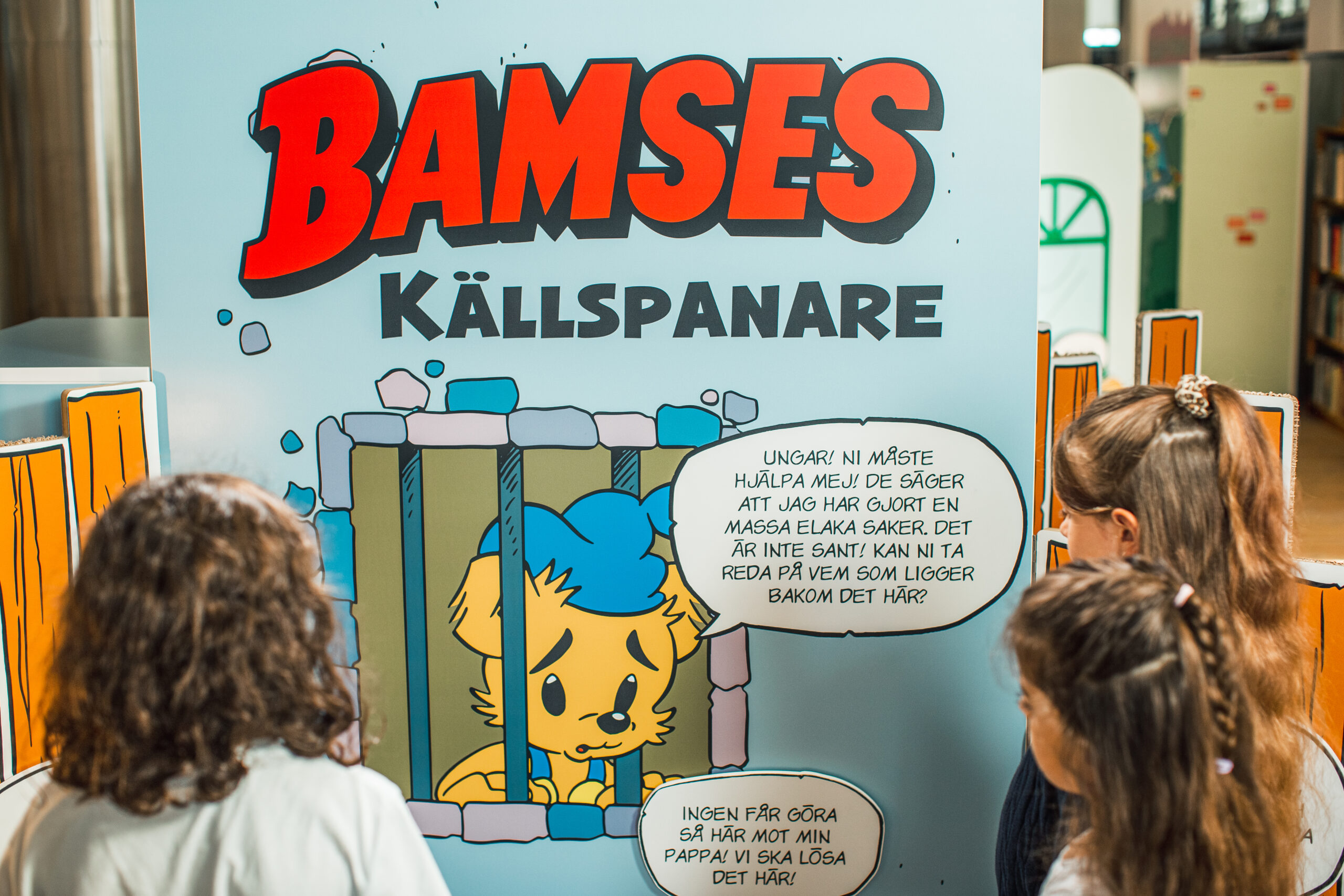 3 barn tittar på utställningen om Bamse.