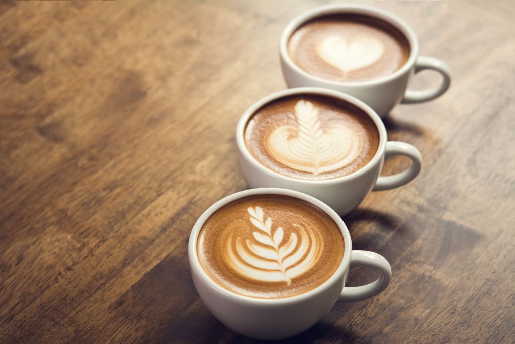 Tre muggar med kaffe står på rad.