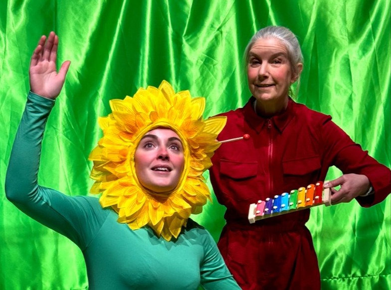 En skådespelare utklädd till en blomma och en xylofonist.