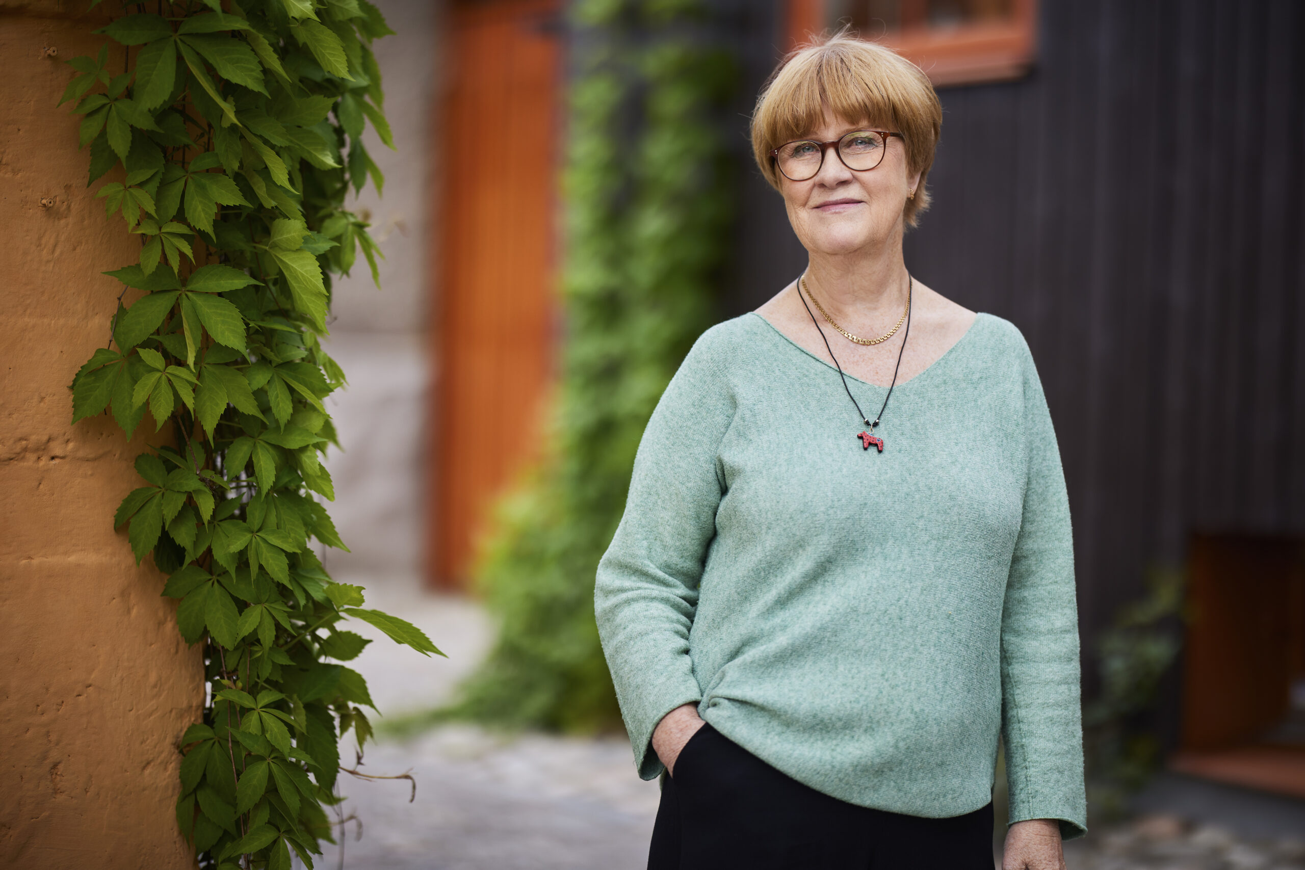 Kvinna och gröna växter i bakgrunden