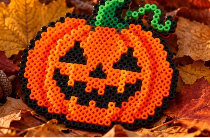 Orange pumpa av pärlor ligger bland höstlöv.
